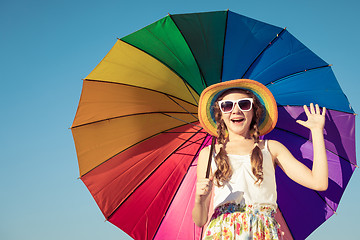 Image showing teen girl with umbrella standing on the beach at the day time.