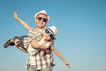 Image showing Father and son playing on the field at the day time.