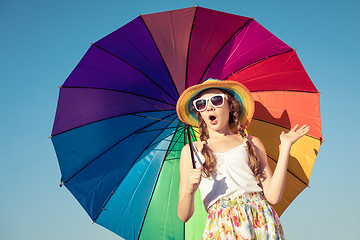 Image showing teen girl with umbrella standing on the beach at the day time.