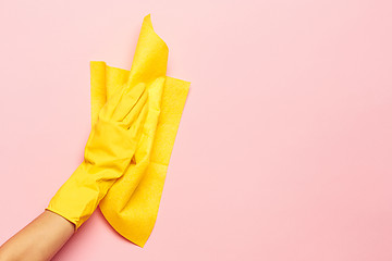 Image showing The woman\'s hand cleaning on a pink background. Cleaning or housekeeping concept