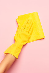 Image showing The woman\'s hand cleaning on a pink background. Cleaning or housekeeping concept