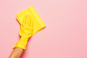 Image showing The woman\'s hand cleaning on a pink background. Cleaning or housekeeping concept