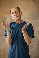 Image showing Worried mature man standing at studio