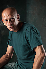 Image showing Worried mature man sitting at studio