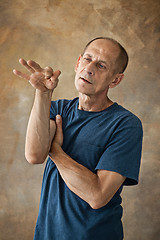 Image showing Worried mature man standing at studio