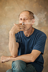 Image showing Worried mature man sitting at studio