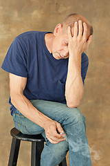 Image showing Worried mature man sitting at studio