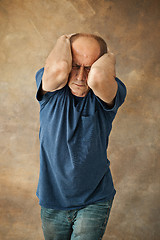 Image showing Worried mature man touching his head.