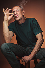 Image showing Worried mature man sitting at studio