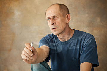 Image showing Worried mature man sitting at studio