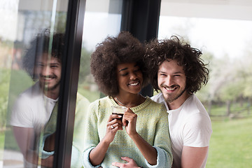 Image showing happy multiethnic couple relaxing at modern home indoors