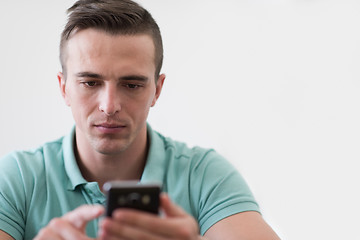 Image showing young man using a mobile phone  at home