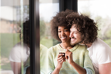 Image showing happy multiethnic couple relaxing at modern home indoors