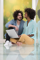 Image showing multiethnic couple using a laptop on the floor