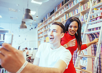 Image showing couple students in univercity library, looking book, preparing t