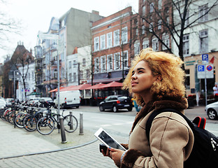 Image showing young cute blond african american girl student holding tablet and smiling, lifestyle people concept 