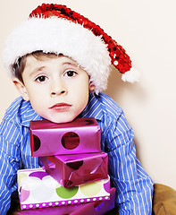 Image showing little cute boy with Christmas gifts at home. close up emotional