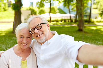 Image showing senior couple taking selfie at summer park 