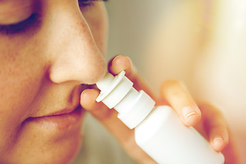 Image showing close up of sick woman using nasal spray