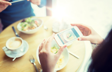 Image showing close up of couple picturing food by smartphone