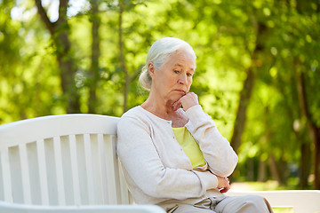 Image showing sad senior woman sitting on bench at summer park