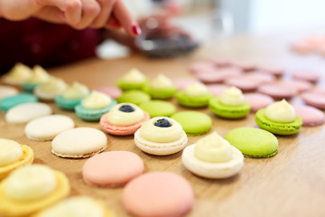 Image showing chef decorating macarons shells at pastry shop