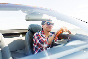 Image showing happy young man driving convertible car