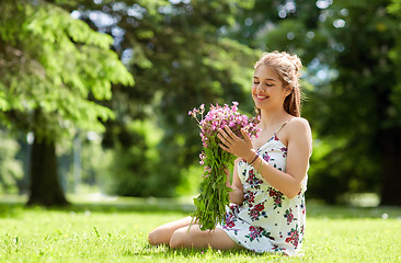 Image showing happy young woman with flowers in summer park