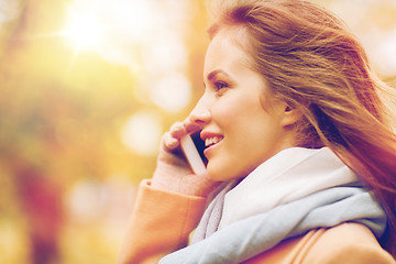 Image showing woman calling on smartphone in autumn park