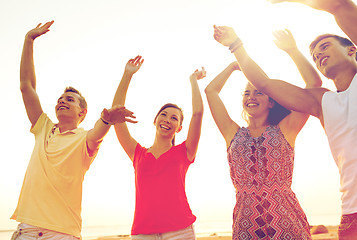 Image showing smiling friends dancing on summer beach