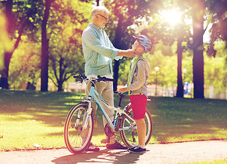 Image showing grandfather and boy with bicycle at summer park