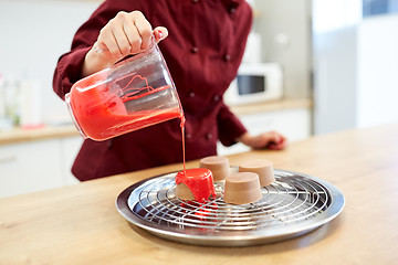 Image showing chef with jug pouring glaze to cake at pastry shop