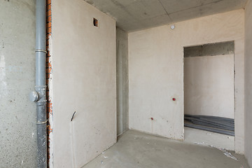Image showing Small kitchen in a new building, bare concrete and plastered walls, communications