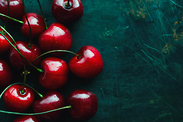 Image showing Ripe cherries on green