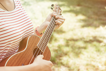 Image showing Anonymous woman playing ukulele