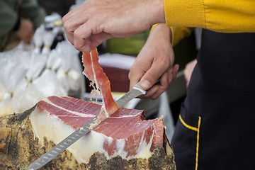 Image showing Slicing dry-cured ham prosciutto on the street market