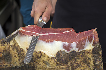 Image showing Slicing dry-cured ham prosciutto on the street market