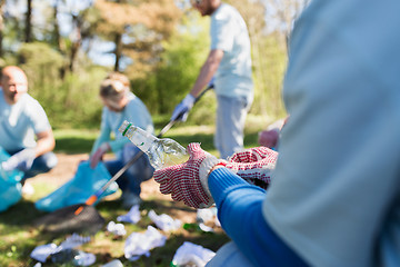 Image showing volunteer with trash bag and bottle cleaning area