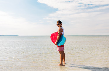 Image showing happy young man with skimboard on summer beach