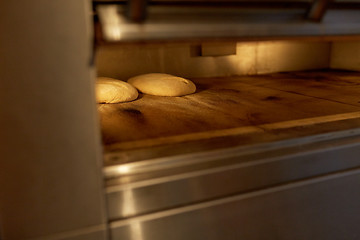 Image showing yeast bread dough in oven at bakery kitchen