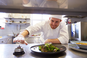 Image showing happy male chef cooking food at restaurant kitchen