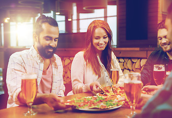 Image showing friends eating pizza with beer at restaurant