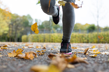 Image showing close up of young woman running in autumn park