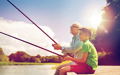 Image showing grandfather and grandson fishing on river berth