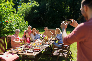 Image showing happy family photographing by smartphone in summer