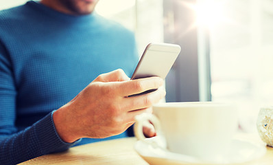 Image showing close up of man with smartphones at cafe