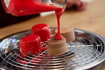 Image showing jug pouring glaze to cakes at pastry shop