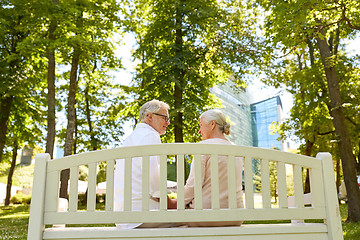 Image showing happy senior couple sitting on bench at park