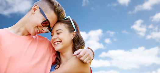 Image showing happy teenage couple hugging over blue sky