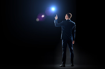 Image showing businessman in suit pointing finger to lens flare